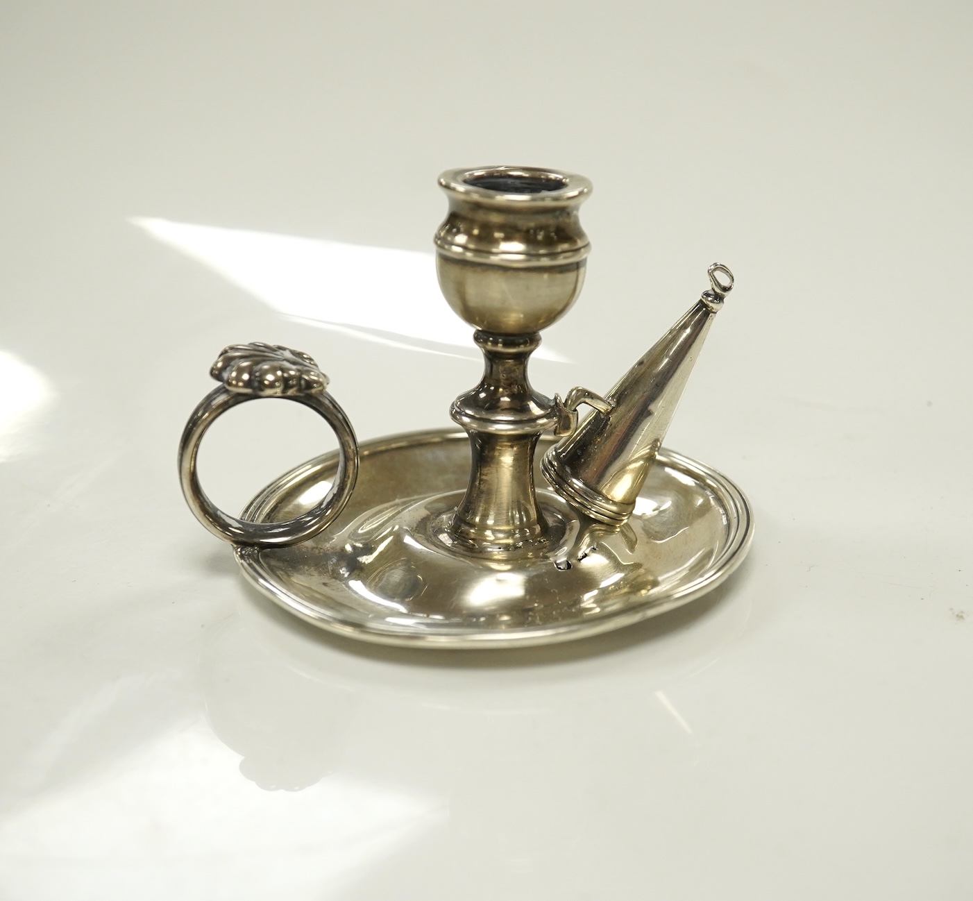 A George III miniature silver chamber stick, Emes & Barnard, London, 1815(a.f.), with matching extinguisher, base diameter 75mm. Condition - poor